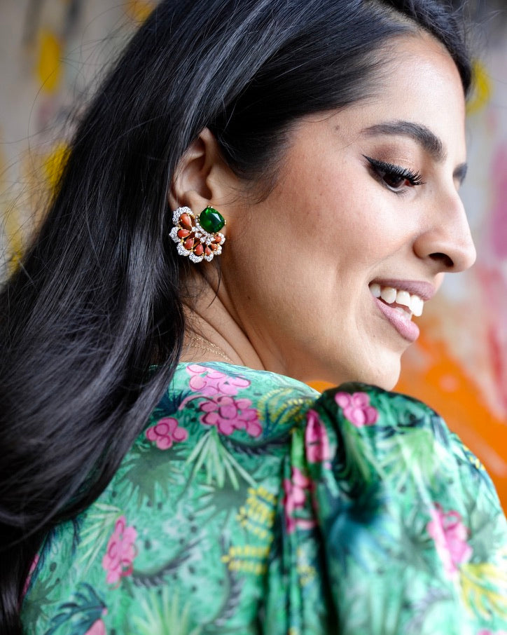 Woman wearing a green floral outfit with a colorful earring
